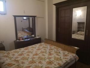 een slaapkamer met een bed, een dressoir en een spiegel bij Cozy 15 min to airport 10 to public transport in Caïro