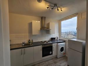 uma cozinha com um lavatório e uma máquina de lavar roupa em Apartment Near Towerbridge em Londres