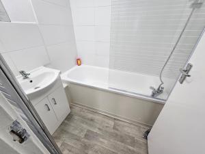 a white bathroom with a tub and a sink at Apartment Near Towerbridge in London