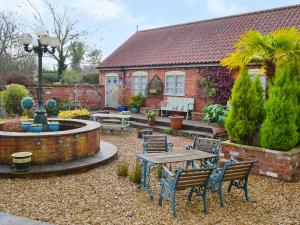 a house with a table and chairs in a yard at Clover Cottage - Uk46269 in Tetney