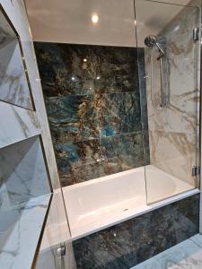 a shower with a glass enclosure in a bathroom at Luxury Apartment in Canary Wharf in London