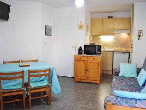 Habitación con mesa y cocina con sofá en Appartement Bormes-les-Mimosas, 2 pièces, 5 personnes - FR-1-251-522, en Bormes-les-Mimosas