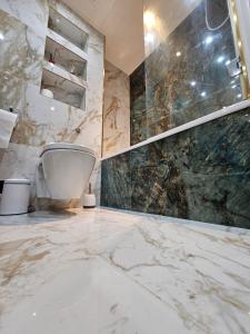 a bathroom with a toilet and marble walls at Luxury Apartment in Canary Wharf in London