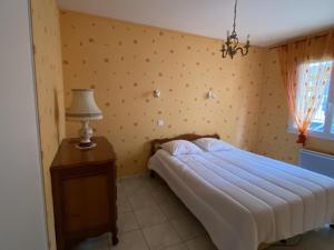 ein Schlafzimmer mit einem Bett und einem Tisch mit einer Lampe in der Unterkunft Maison La Bernerie-en-Retz, 5 pièces, 9 personnes - FR-1-612-128 in La Bernerie-en-Retz