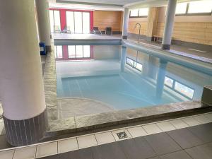 ein großer Pool mit blauem Wasser in einem Gebäude in der Unterkunft Appartement Risoul, 2 pièces, 4 personnes - FR-1-330-569 in Risoul