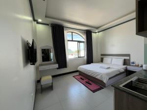 ein kleines Schlafzimmer mit einem Bett und einem Fenster in der Unterkunft Khách Sạn Nhà Đất in Ấp Bình Hưng