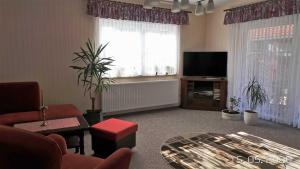 a living room with a couch and a television at Ferienwohnung Reulecke in Blankenburg