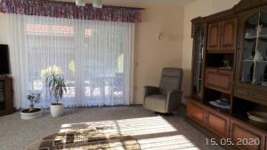 a living room with a chair and a large window at Ferienwohnung Reulecke in Blankenburg