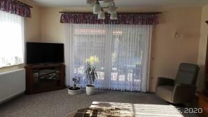 a living room with a television and a window at Ferienwohnung Reulecke in Blankenburg