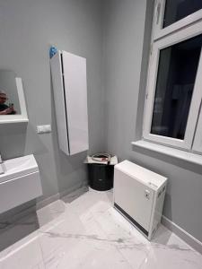 a white bathroom with a sink and a window at Odra River Condo in Szczecin