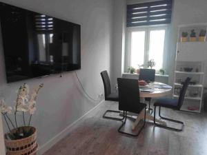 a living room with a dining room table and chairs at Odra River Condo in Szczecin