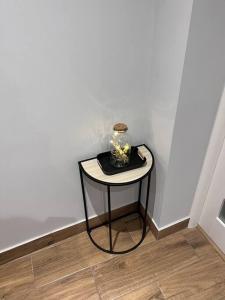 a small table in a corner with a vase on it at Odra River Condo in Szczecin