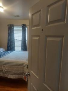 a bedroom with a bed and a door with a window at Crystal Room 1 Guest House near 12mins to EWR airport / Prudential / NJIT / Penn station in Newark