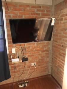 TV de pantalla plana colgada en una pared de ladrillo en El Serafín en Cortaderas