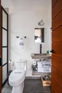 a bathroom with a white toilet and a sink at La Fábrica #6 Can Bonastre in Valle de Bravo +25 photos