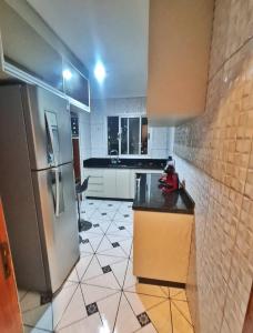 a kitchen with a refrigerator and a tile floor at Apto 8° andar, 4 min do shopping. in São Paulo