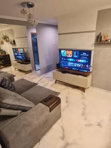 ein Wohnzimmer mit einem Sofa und einem Flachbild-TV in der Unterkunft Apto 8° andar, 4 min do shopping. in São Paulo