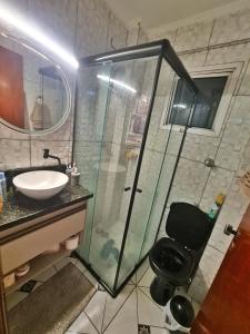 La salle de bains est pourvue d'une douche en verre et d'un lavabo. dans l'établissement Apto 8° andar, 4 min do shopping., à São Paulo