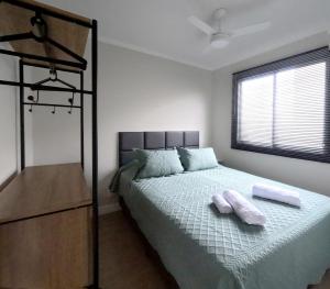 a bedroom with a bed with two towels on it at Apto Confortável prox ao Allianz in Sao Paulo