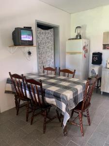 cocina con mesa, sillas y nevera en Casa bem localizada Cidreira, en Cidreira