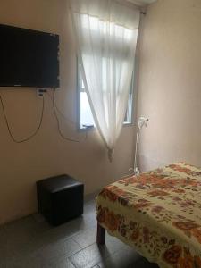 een slaapkamer met een bed, een tv en een raam bij Casa bem localizada Cidreira in Cidreira