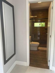 a bathroom with a toilet and a door leading to a bathroom with a toilet sqor at Studio Flor do Mato in Itapema