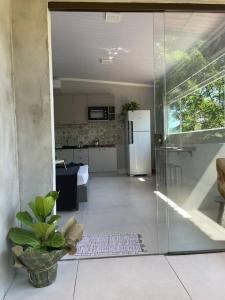 eine Küche mit einem Kühlschrank und einer Topfpflanze in der Unterkunft Studio Flor do Mato in Itapema