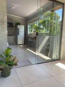 uma sala de estar com uma porta de vidro deslizante e uma cozinha em Studio Flor do Mato em Itapema