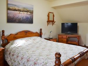 a bedroom with a bed and a flat screen tv at Buttermilk Cottage - Uk46270 in Tetney