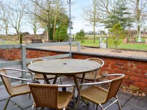 a wooden table and chairs on a patio at Buttermilk Cottage - Uk46270 in Tetney