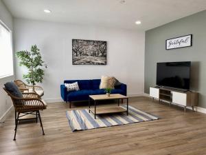 a living room with a blue couch and a tv at Uniquely remodeled historical district home in Phoenix