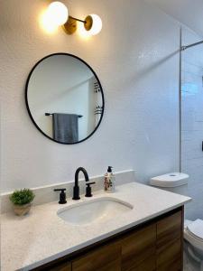 a bathroom with a sink and a mirror at Uniquely remodeled historical district home in Phoenix