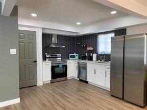 uma cozinha com armários brancos e um frigorífico de aço inoxidável em Uniquely remodeled historical district home em Phoenix