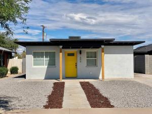 uma pequena casa com uma porta amarela em Uniquely remodeled historical district home em Phoenix