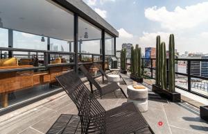 a balcony with two chairs and cactus on a building at Casa Insurgentes by Kukun in Mexico City