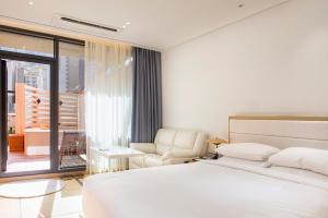 釜山にあるノンシム ホテルのベッドルーム1室(ベッド1台、椅子、窓付)