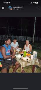 un grupo de personas sentadas en una mesa comiendo comida en ROCA'S HOMESTAY Backpackers Chalet Bohol, en Batuan