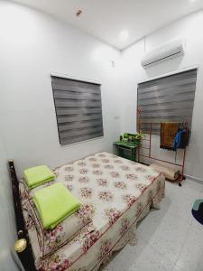 a bedroom with a bed with green towels on it at Aufa House in Padang Rengas