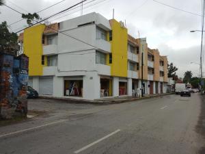 un edificio amarillo y blanco al lado de una calle en Chinelos Express Desayuno en cortesia, en Cuernavaca