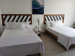 dos camas sentadas una al lado de la otra en una habitación en Chinelos Express Desayuno en cortesia, en Cuernavaca