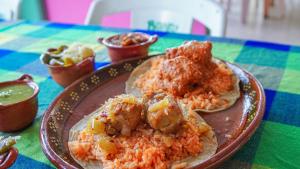 een bord met rijst en vlees op een tafel bij Chinelos Express Desayuno en cortesia in Cuernavaca