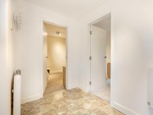 an empty hallway with white walls and tile floors at Lazy Acre in Holbeach