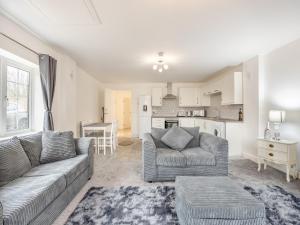 a living room with two couches and a kitchen at Lazy Acre in Holbeach