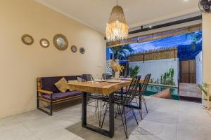 a dining room with a table and chairs and a couch at Villas Krisna Canggu WCS in Canggu