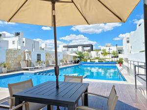 una mesa con sombrilla junto a la piscina en Casa con alberca Mirador 126, en Querétaro