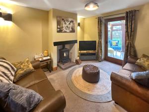 a living room with a couch and a fireplace at Helm View in Blencarn