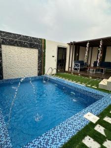 een zwembad in de tuin van een huis bij شاليه in Al Maʼish