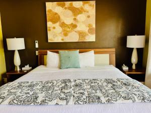 a bedroom with a large bed with two lamps at The Flagstone Boutique Inn & Suites in Kanab