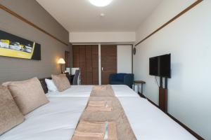 那覇市にあるKINTARO Hotel Okinawa Nahaのベッドとテレビがあるホテルの部屋 +36枚の写真