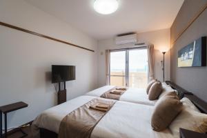 那覇市にあるKINTARO Hotel Okinawa Nahaのベッドルーム(大きな白いベッド1台、窓付)